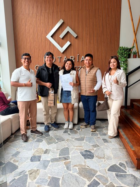 Propietaria con su contrato junto a familiares y asesores en la notaría