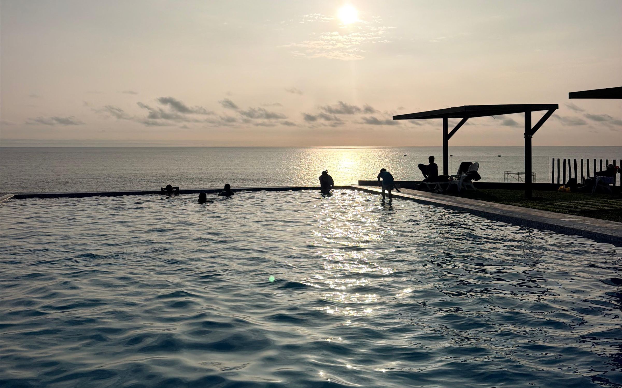 Atardecer sobre el océano desde la piscina infinita del condominio